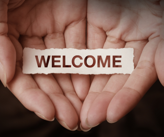 hands open with a sign saying welcome