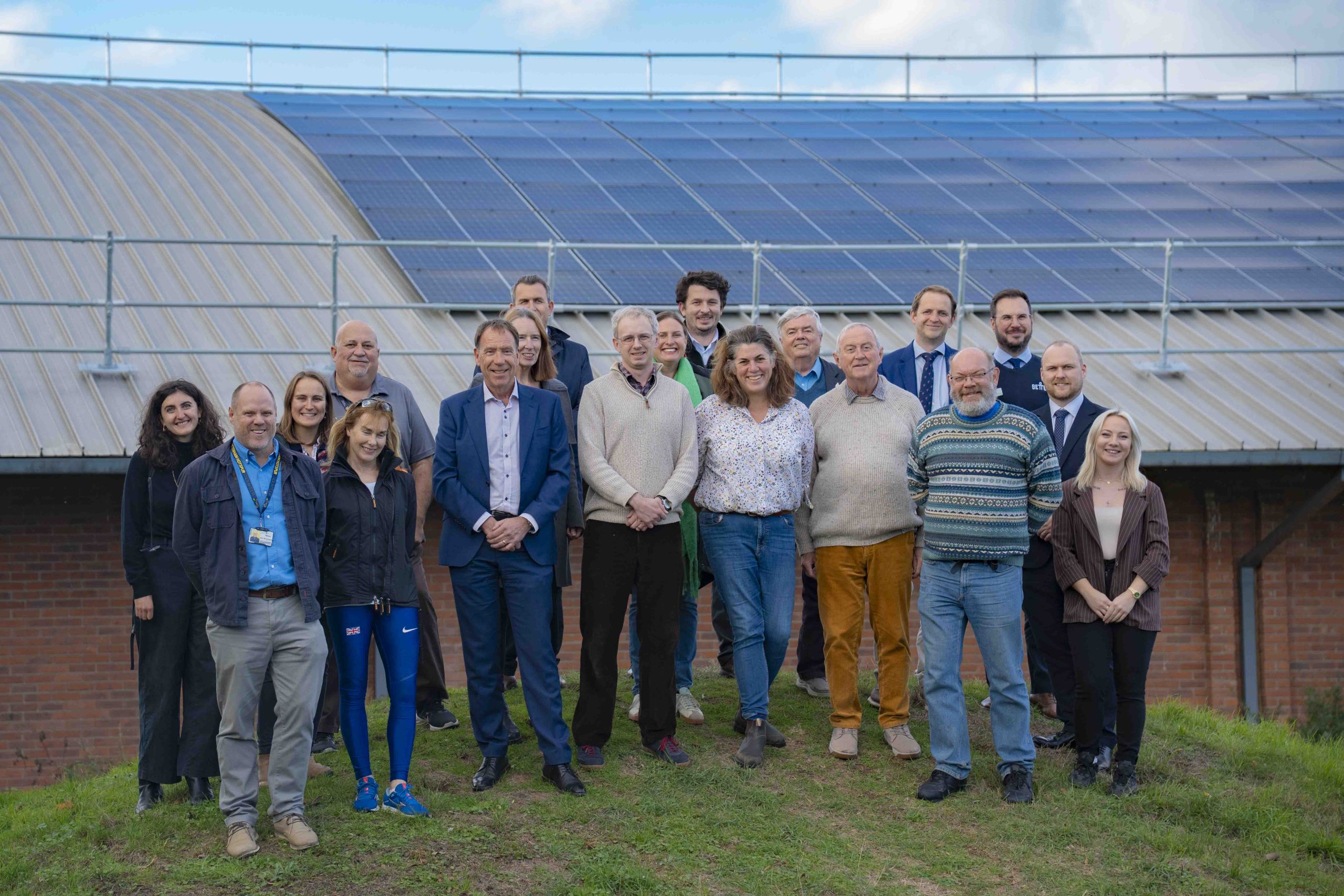 Councillors, contractors and staff show off some of the solar panels on the roof of the leisure centre building