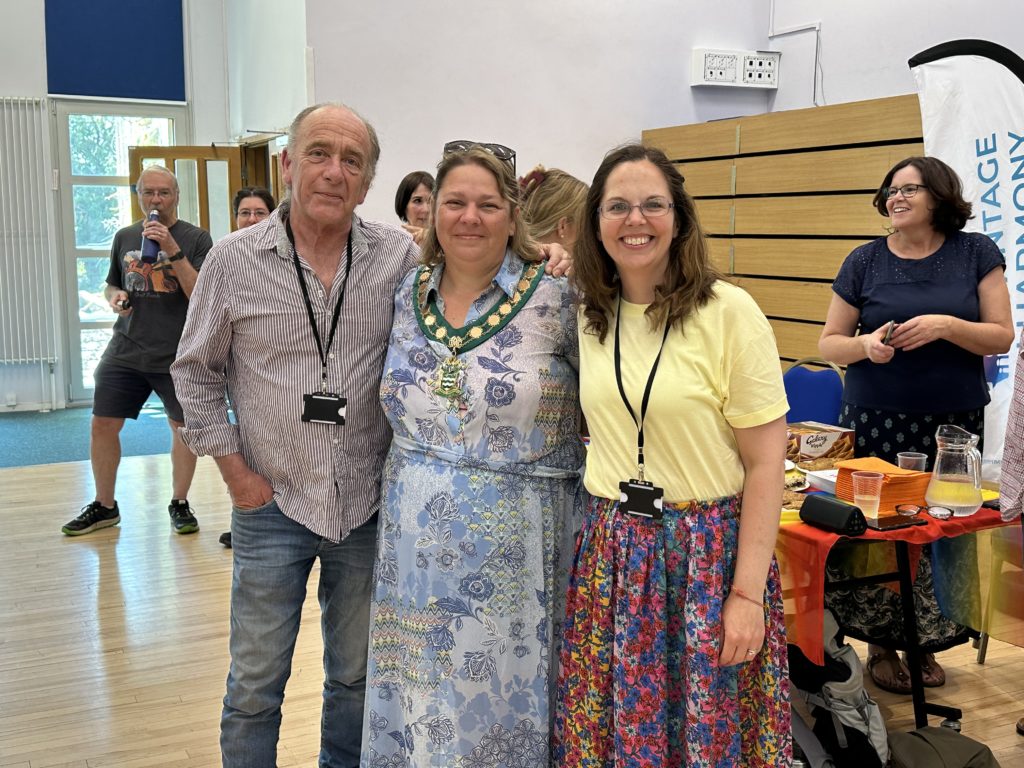 Three councillors posing inside a community centre hall