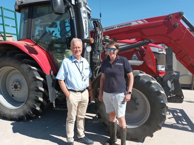 Cllr Paul Barrow in front of tractor with farmer